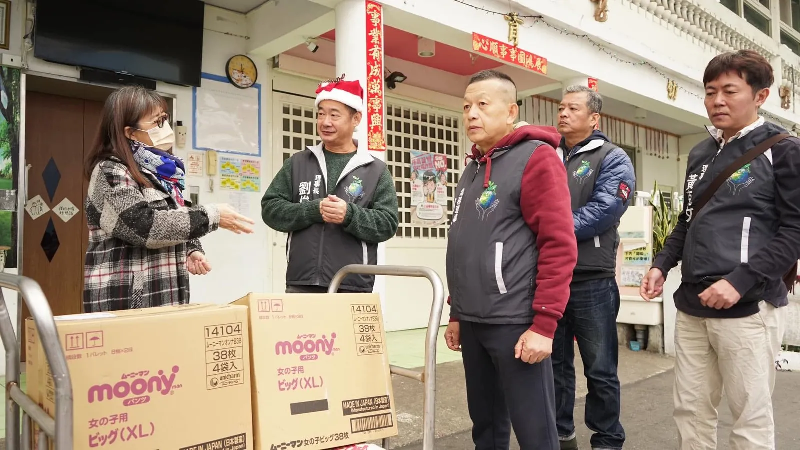 院方人員與協會理監事在成箱的捐贈物資旁交談