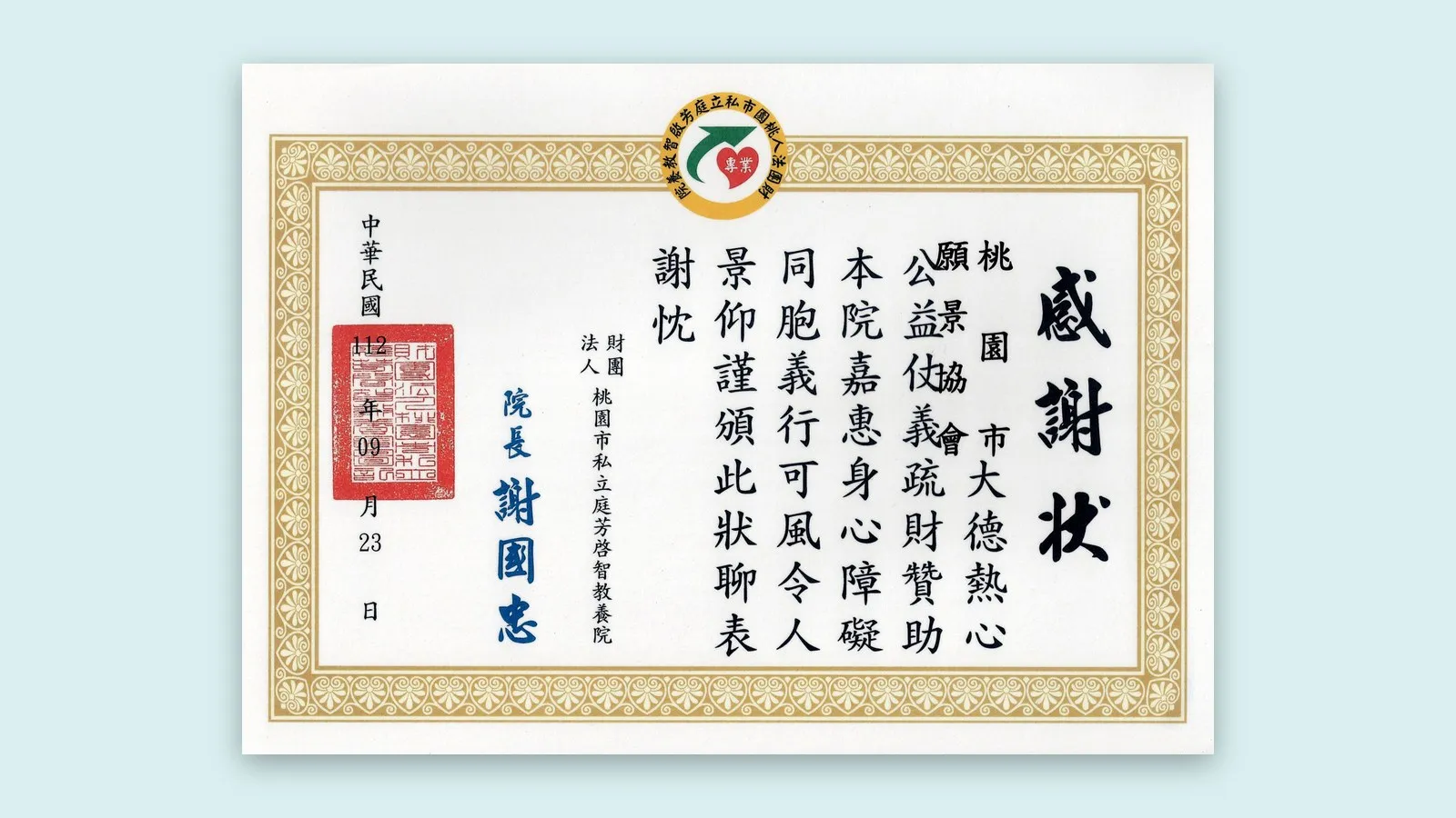 庭芳啓智教養院感謝狀置於青色襯底上