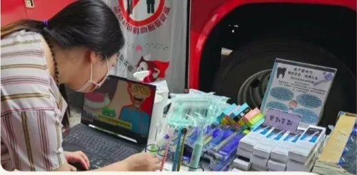 捐血車旁的口腔衛教攤位，桌上擺著潔牙用品與宣導資料